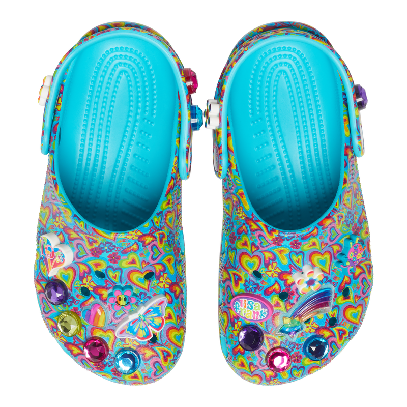 Kids´ classic Lisa Franck clog, view from the top; each shoe is decked out in signature Lisa Frank designs with colorful hearts on a blue background and includes a whimsical and wonderful collection of Jibbitz™ charms. The left one has the heart that says love, a butterfly, purple, green, pink, and blue diamonds, and a flower; the left one has a flower, a shooting star in rainbow colors, a bag that says Lisa Frank, and the color diamonds purple, pink, and blue.