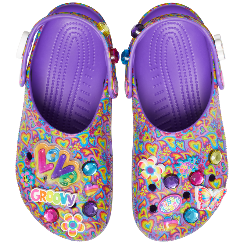 Classic Lisa Franck Crocs from the top each shoe is decked out in signature Lisa Frank designs with colorful hearts on a purple background and includes a whimsical and wonderful collection Jibbitz™ charms like the piece and love sine with the lisa frank colors, a flower, a butterfly, a red, purple and blue diamond and the word groovy in different colors, and a love charm.