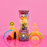 Lisa Frank Rainbow Leopard Blendjet 2 portable blender at the bottom is the rainbow fades colors pink, orange, yellow, green, and purple; with the blend button, with a pink cap, at the top, it has a leopard pattern in different colors with a black outline and a little plastic purple strap on the left side of the cap, inside the blender there different kinds of fruit, on the side of the product there are some decoration fruits like papaya, orange, kiwi, melon and raspberry’s.